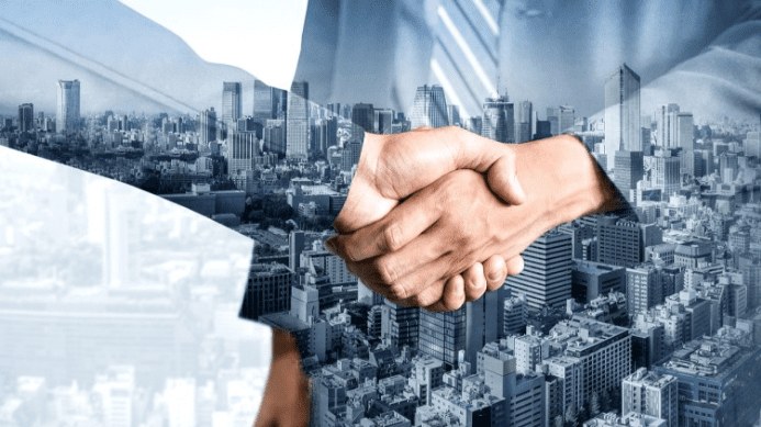 Professional handshake representing a business merger and acquisition transaction.